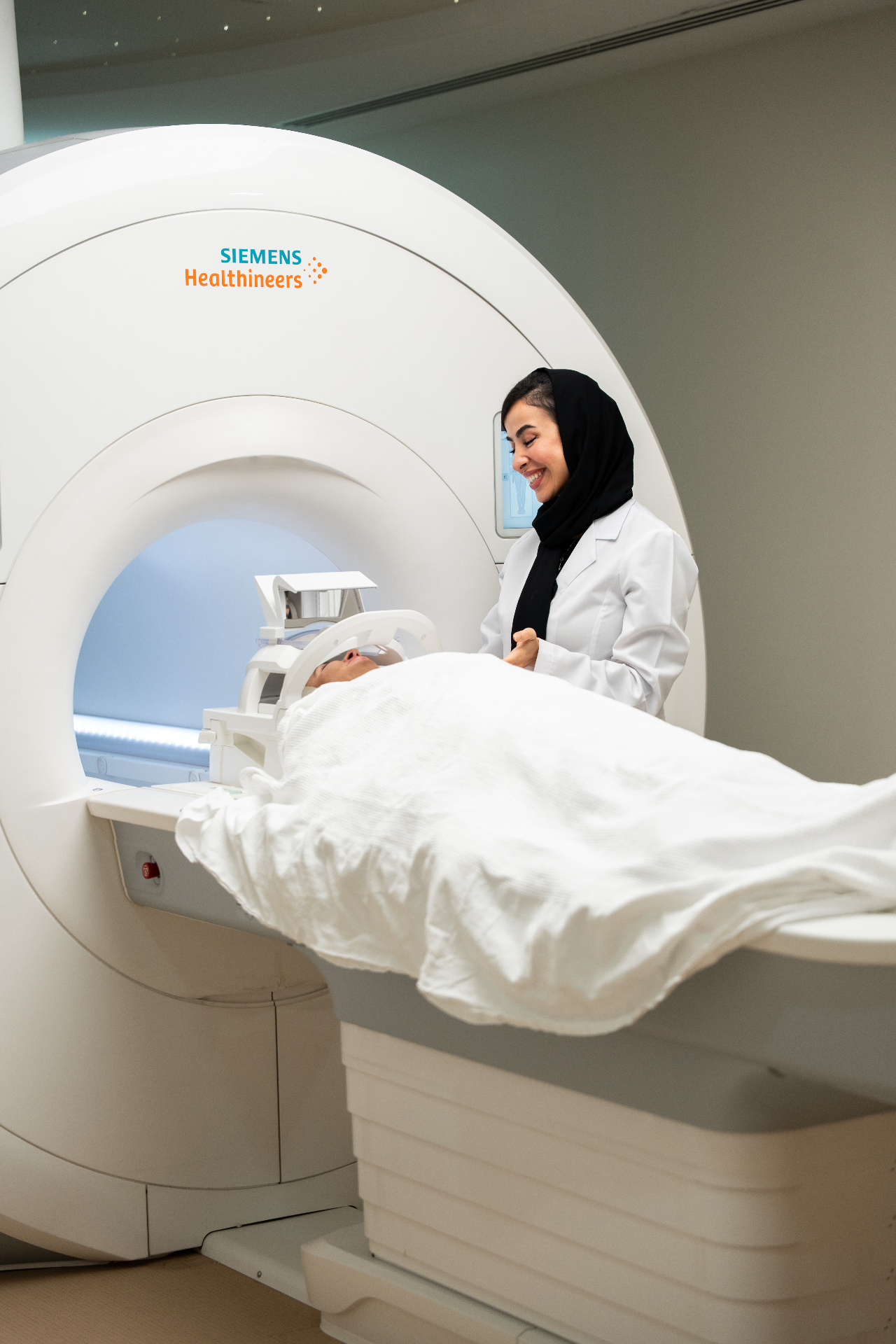 Radiologist supporting a patient at the MRI scanner